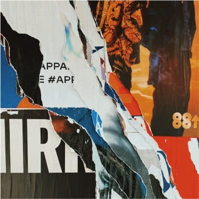 Layers of torn printed posters peeling away from a wall