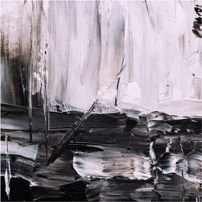 A close up of thickly applied black and white oil paint on canvas